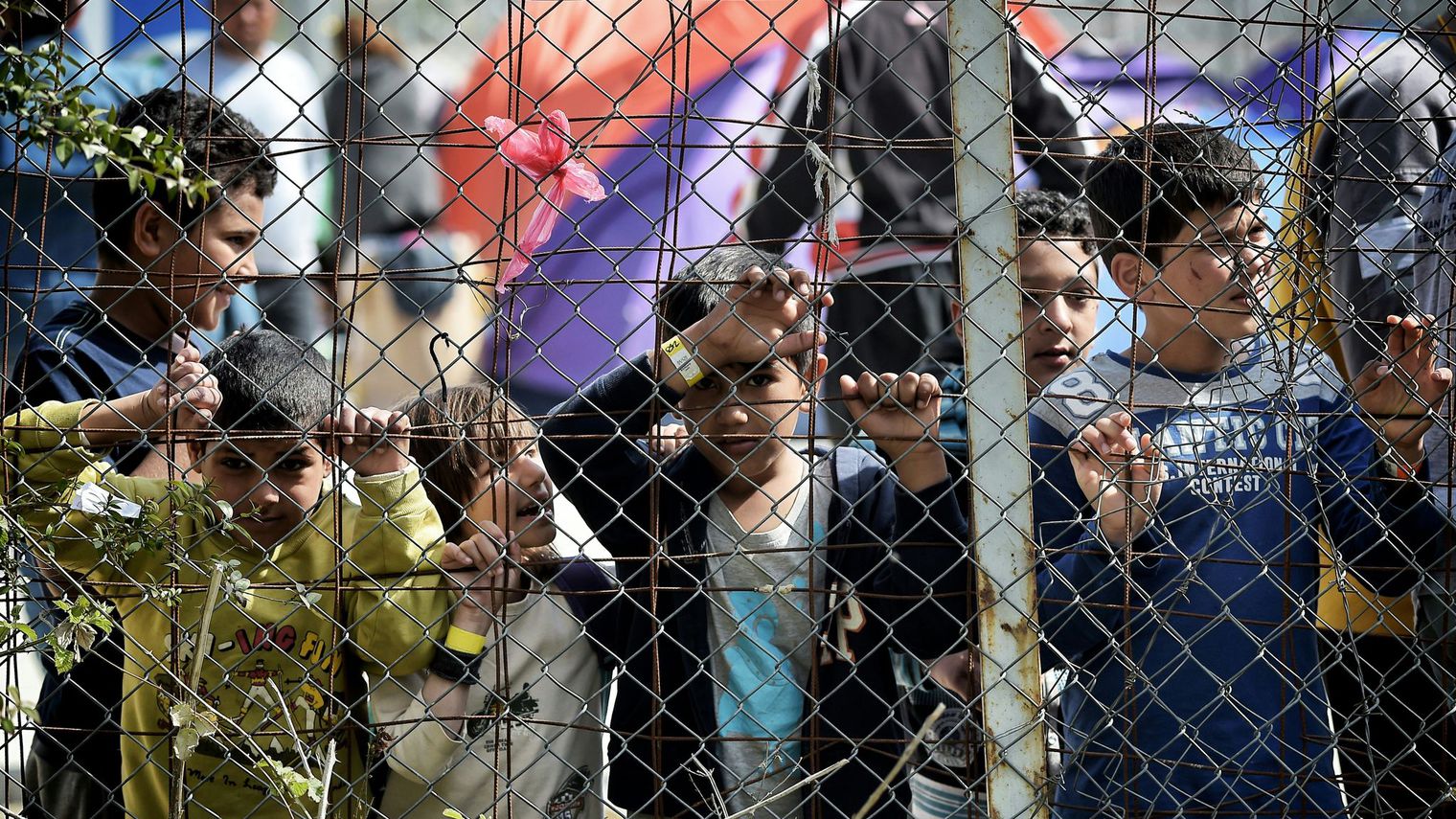 des-enfants-se-tiennent-derriere-le-grillage-entourant-le-camp-de-migrants-de-moria-transforme-en-camp-de-detention-a-mytilene-sur-l-ile-grecque-de-lesbos-le-3-avril-20